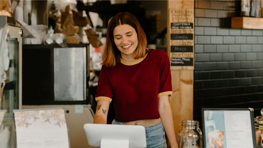 Staff member smiling in a restaurant after learning how to open and run a successful venue in Australia